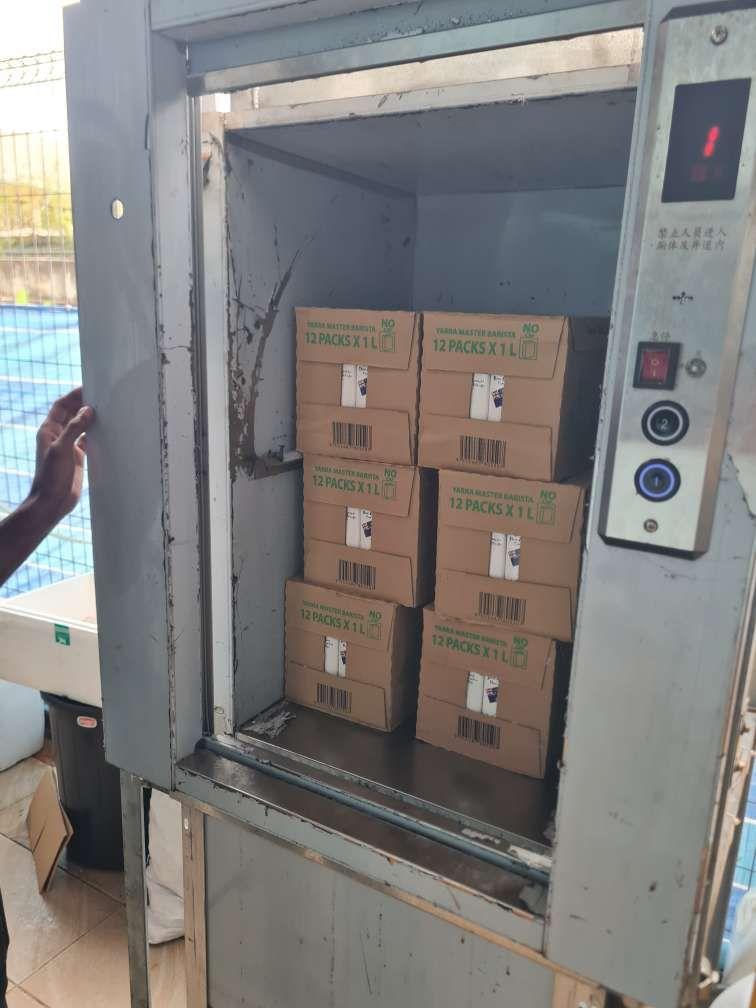 Master Barista milk boxes stacked inside a small goods lift.